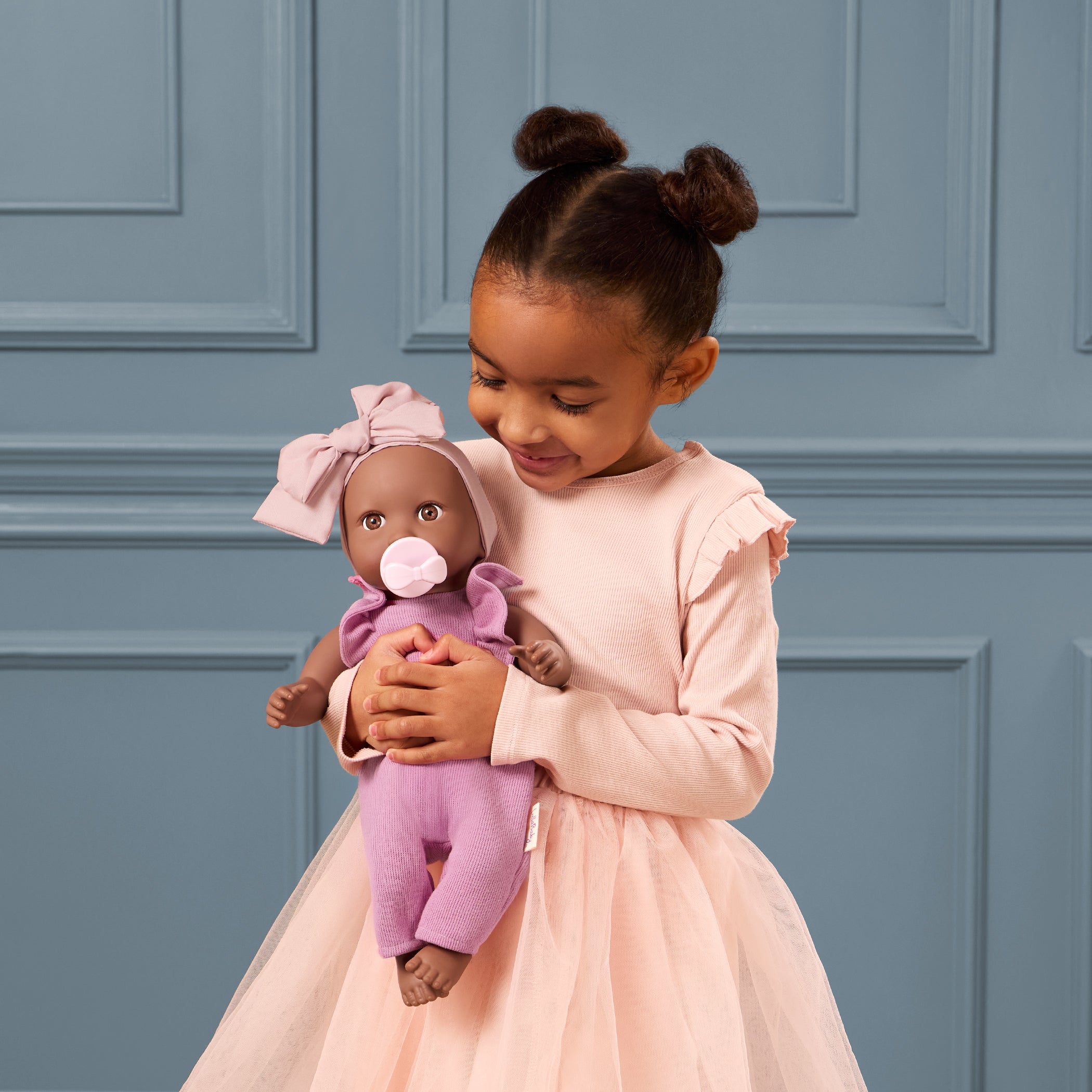 LullaBaby doll in purple romper